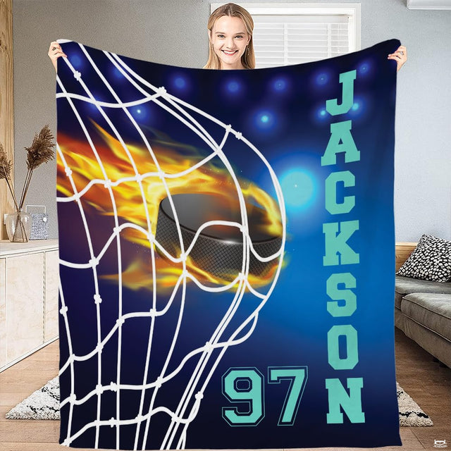 Full flat view of flaming hockey puck throw blanket showing arena lights and vertical varsity text.