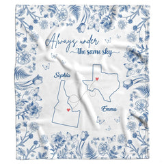 Blue botanical state map throw blanket folded neatly showing cobalt floral borders and white ground