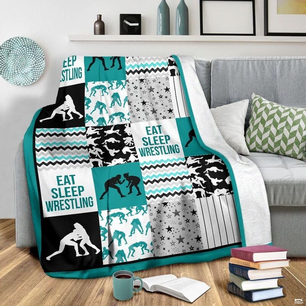 Flat layout of teal and black wrestling blanket displaying athlete silhouettes and chevron patterns.