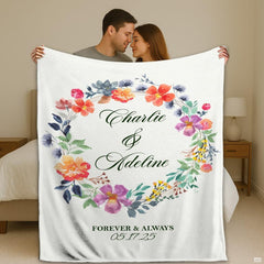 Wedding gift bedding showcasing a circular watercolor floral wreath with coral and lavender blossoms on white.