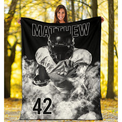 Folded athletic blanket highlighting white smoke billows and jersey digits
