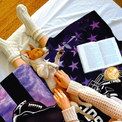 Overhead view of reader with sleeping puppy on white bedding beside the cosmic sports design.