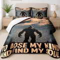 Bigfoot silhouette walking through evergreen pine trees on a mountain style bedding set display.