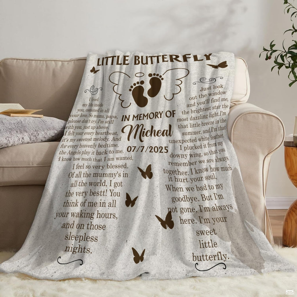 Winged infant footprints memorial blanket arranged across living room couch.