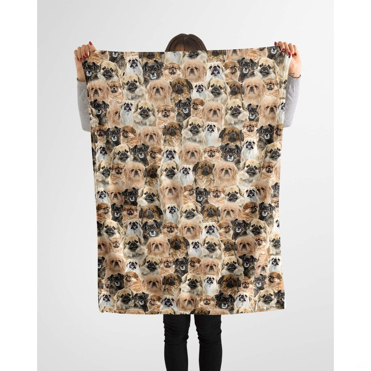 Model holding up a repeating Pekingese canine blanket against a plain background.