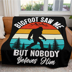 Close up of retro Bigfoot throw blanket highlighting multicolored sunset stripes and pine tree graphics