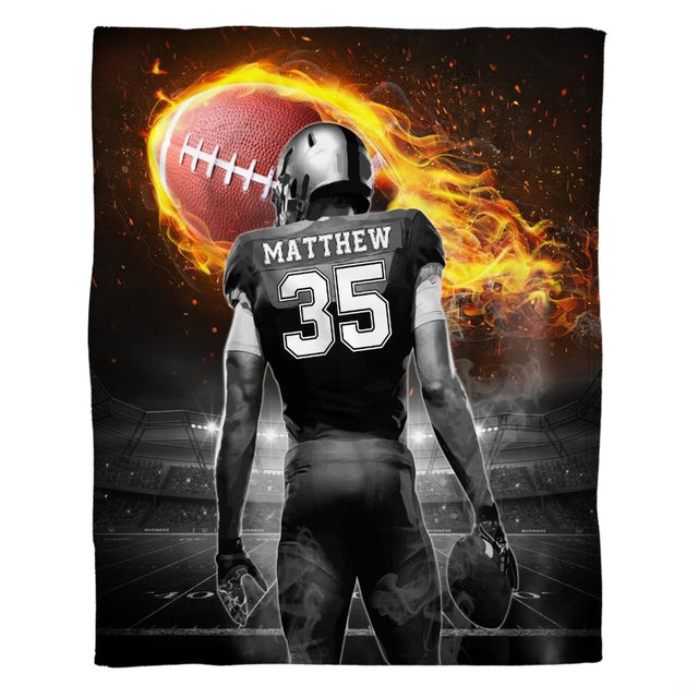 Football player beneath a blazing flaming football in a stadium, view 2.