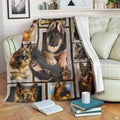 German Shepherd blanket draped over an armchair displaying framed dog portraits on a teal background.