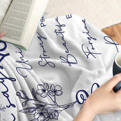 Scripture floral art throw blanket draped across a living room couch.