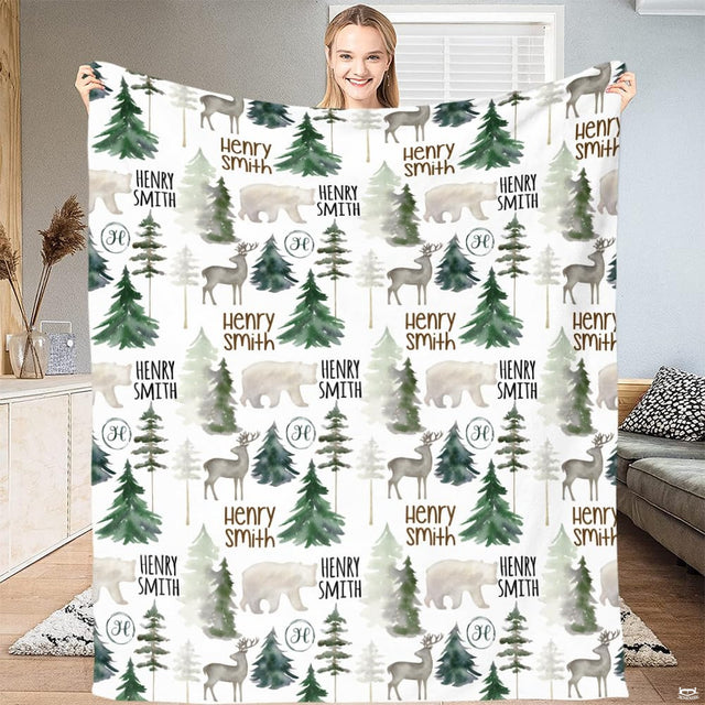 Woodland forest nursery bedding styled in a bedroom setting with deer and pine tree artwork.