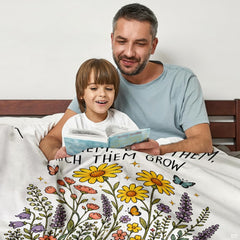 Close up of teacher wildflower throw blanket highlighting yellow daisies, lavender spires, and typography