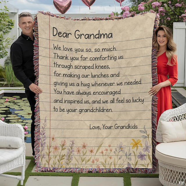 Full outdoor view of fringed throw blanket showing ruled stationery graphic, handwritten text, plus wildflowers.