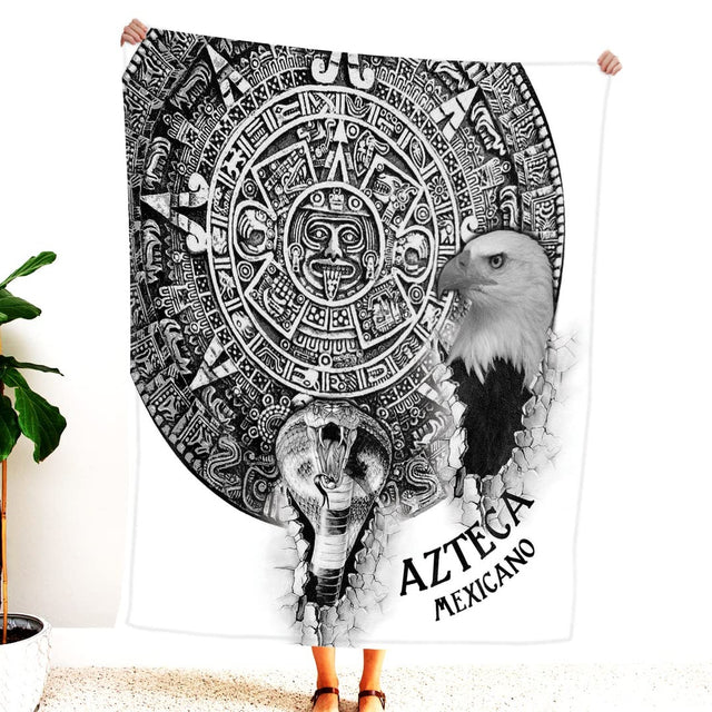 Person holding up black and white Aztec calendar blanket displaying eagle and serpent emerging from stone