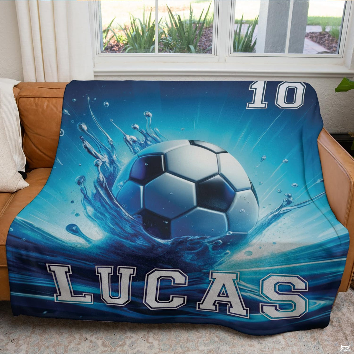 Bedding styled in a modern bedroom displaying vibrant cyan motion rays and soccer ball graphics.