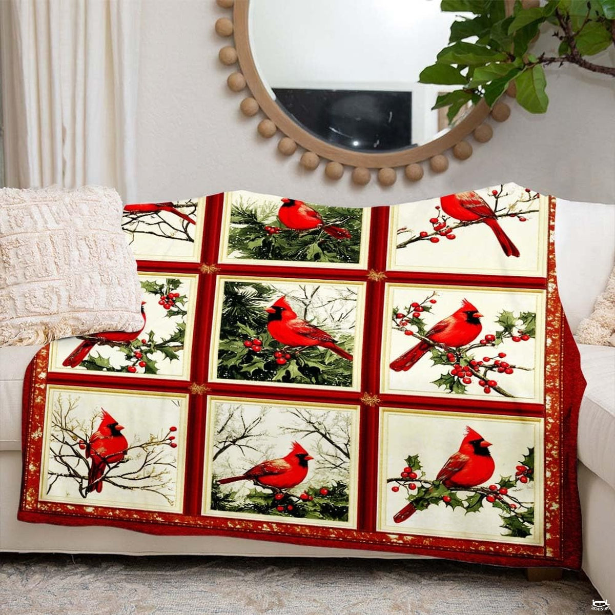 Folded presentation of the red cardinal collage blanket resting neatly on an armchair.