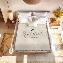 Detail of typewriter style date lettering and textured neutral ground on a romantic blanket