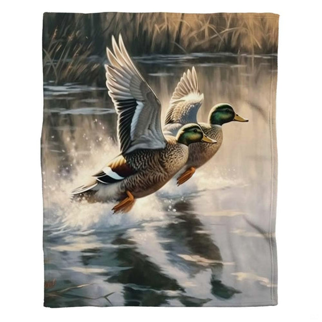 Two mallard ducks in mid-flight soaring above glistening wetland pond waters on a throw blanket