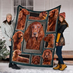 Two models displaying the Irish Setter blanket outside a snowy winter home entrance.