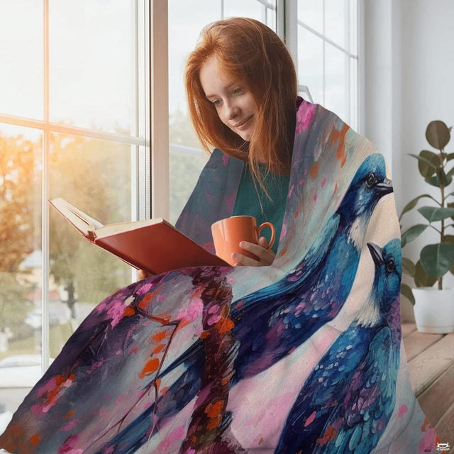 Bluebirds on cherry blossom throw blanket view 2 highlighting bluebird plumage, pink petals, and home decor