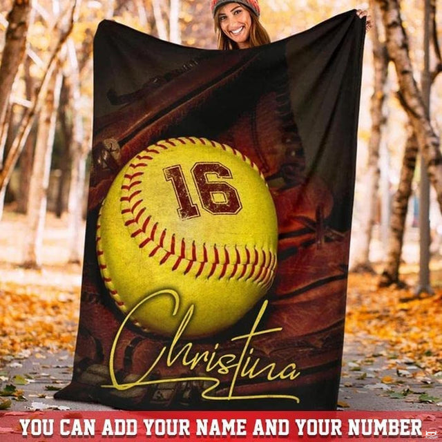 Woman displaying the softball throw blanket outdoors in an autumn park setting.