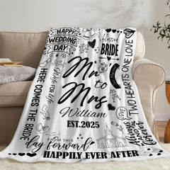 Folded black and white wedding throw blanket resting on wooden bedroom bench