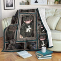 Staffordshire Bull Terrier blanket draped over an armchair displaying framed dog portraits on a teal background.