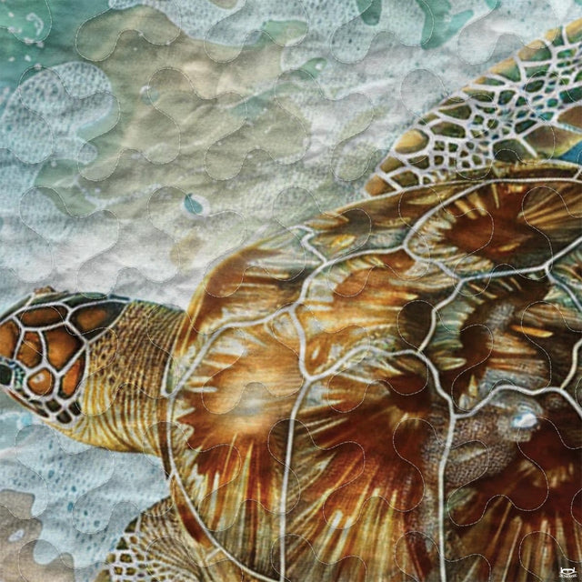Close-up view of turtle bedding showcasing intricate Polynesian tribal motifs and pastel aqua tones