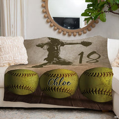 Softball throw blanket arranged over a neutral couch beneath a circular decorative wall mirror.