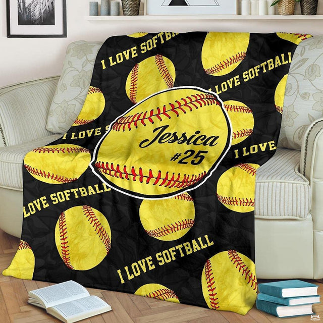 Fastpitch optic balls pattern fan blanket draped over sofa beside books