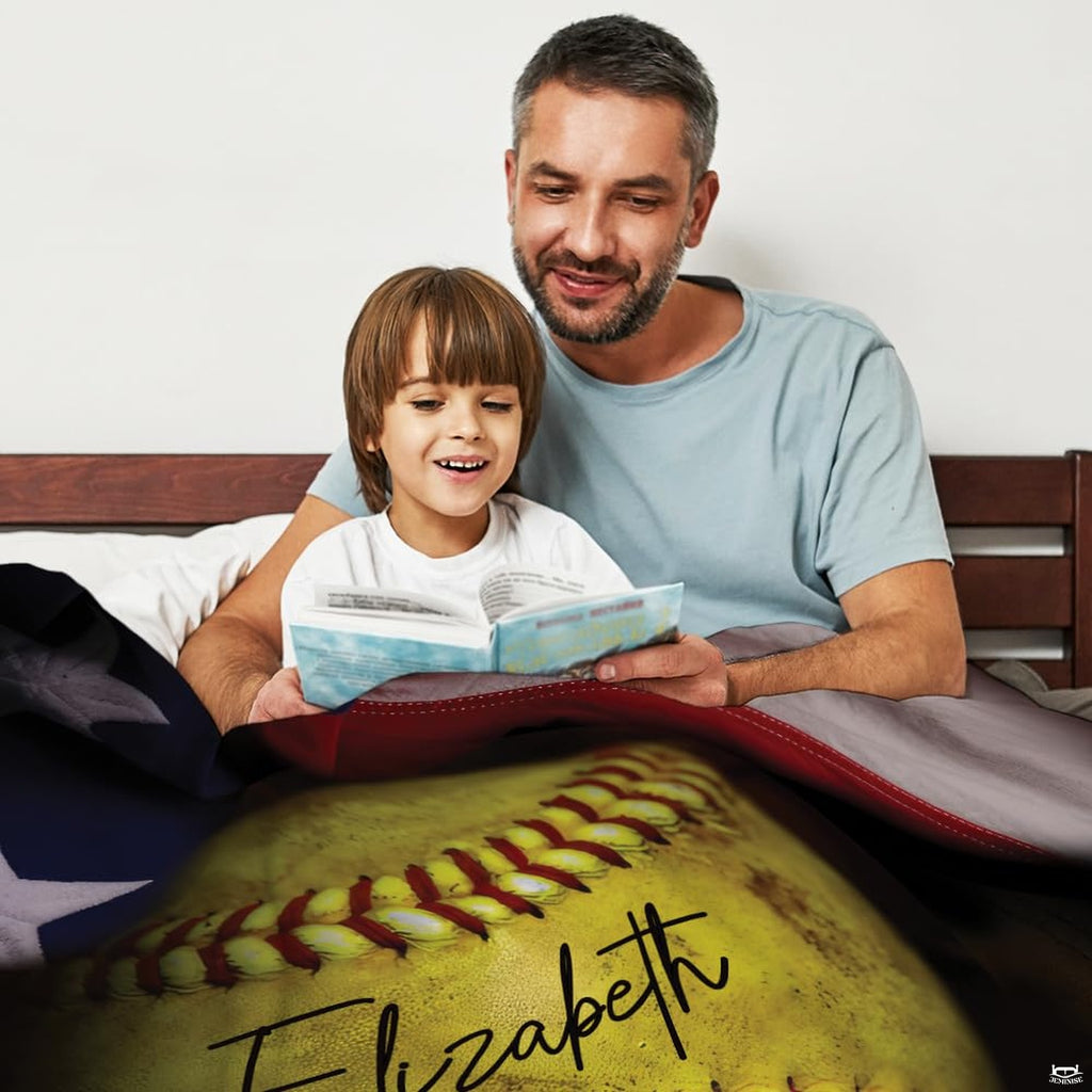 Father and child reading together under patriotic softball throw blanket on wooden bed