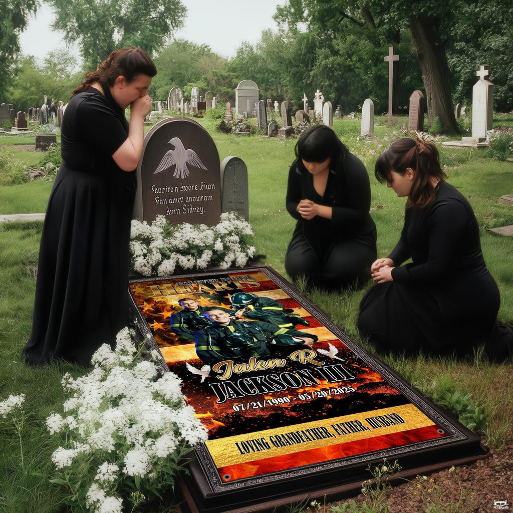 Mourners kneeling in prayer beside installed firefighter memorial grave blanket at cemetery