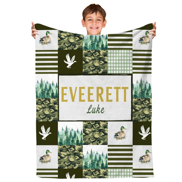 Child holding the mallard duck camouflage throw blanket showing rustic outdoor composition.