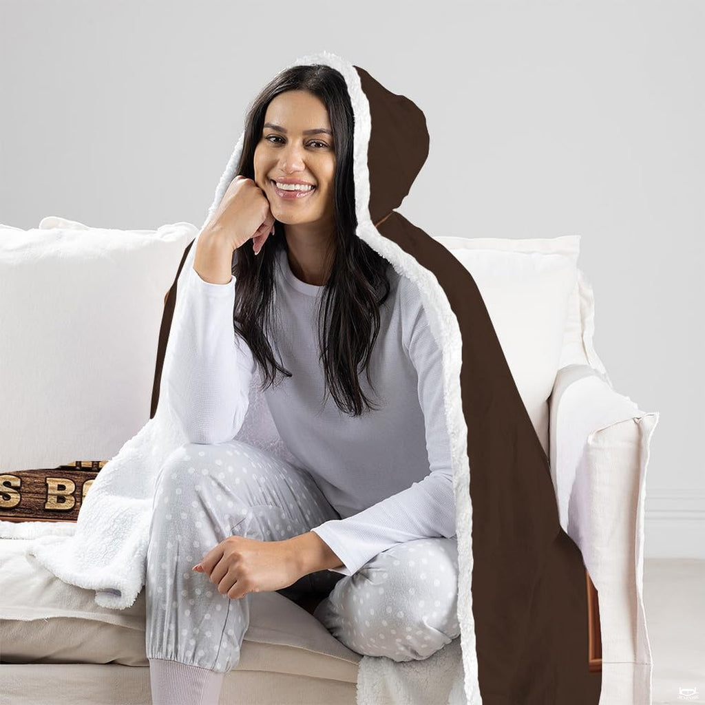 Reader throw blanket draped over a living room couch beside a full bookshelf