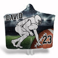 Football lineman stadium throw blanket depicting illustrated player in ready stance on turf under lights