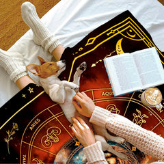 Zodiac lion celestial blanket draped neatly over a living room couch beside an accent pillow.