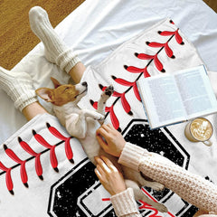 Living room decor setting featuring baseball jersey throw blanket draped over modern sectional sofa