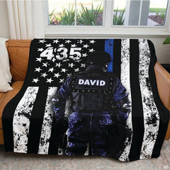 Tactical police tribute blanket draped over domestic armchair
