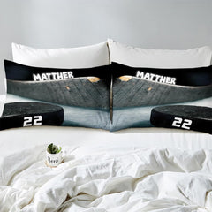 Side angle view of athletic winter sports bedding showing charcoal black and slate grey tones on mattress