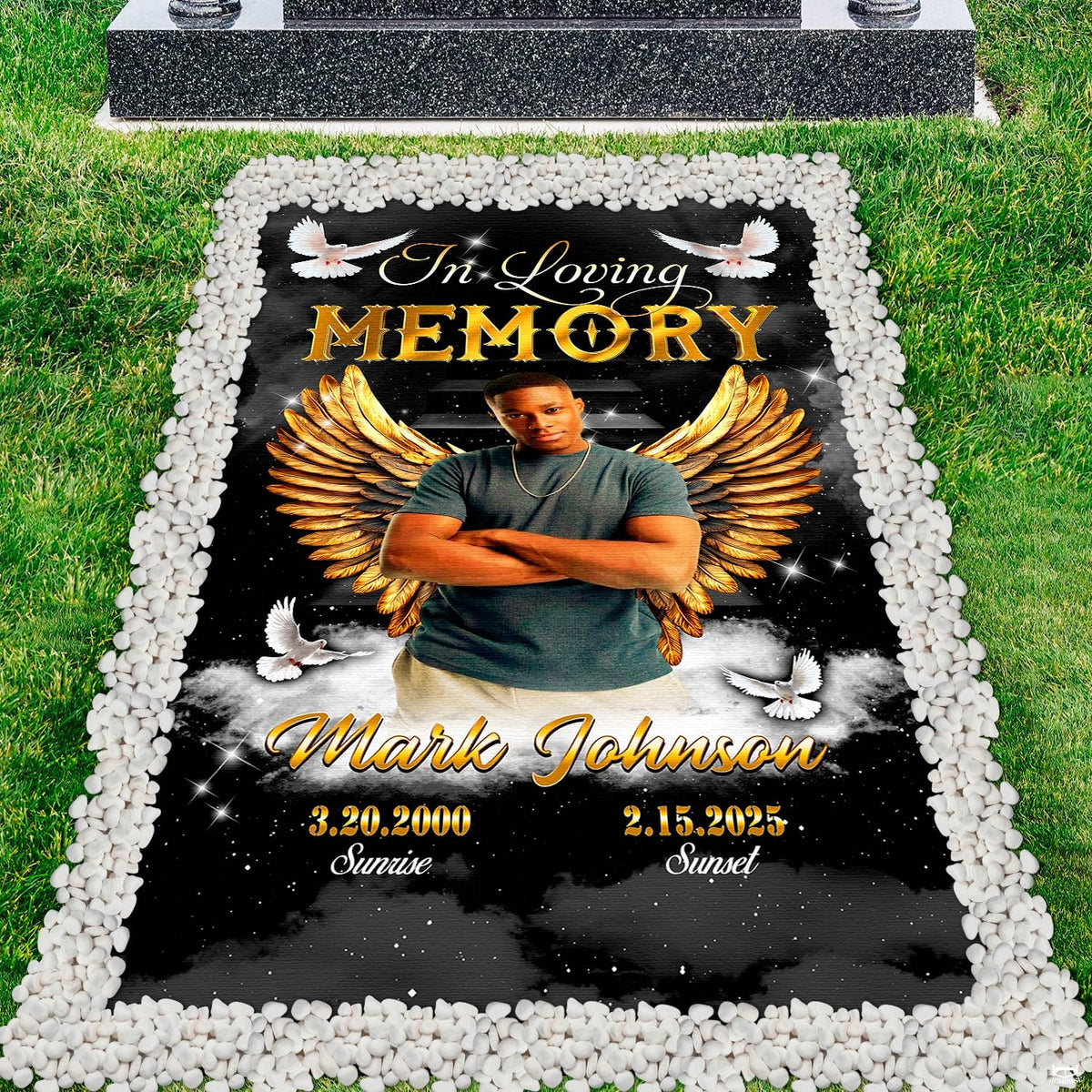 Top-down cemetery perspective showing celestial angel wings tribute placed before a polished headstone.