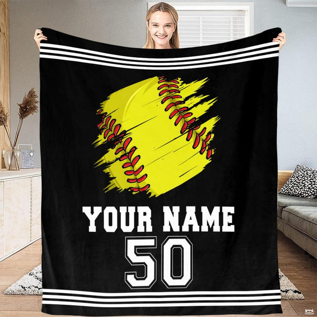 Person standing in bright living room holding up distressed yellow softball graphic textile.