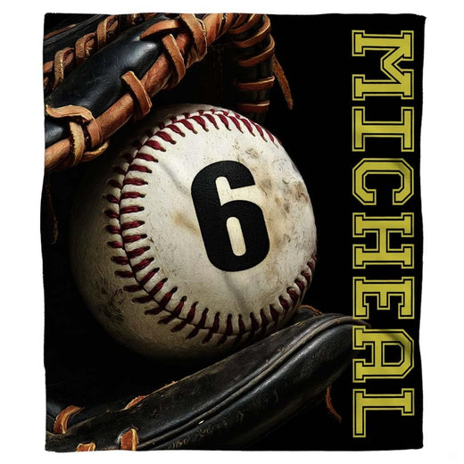Authentic baseball in a black fielder glove beside vertical gold varsity lettering, view 1.