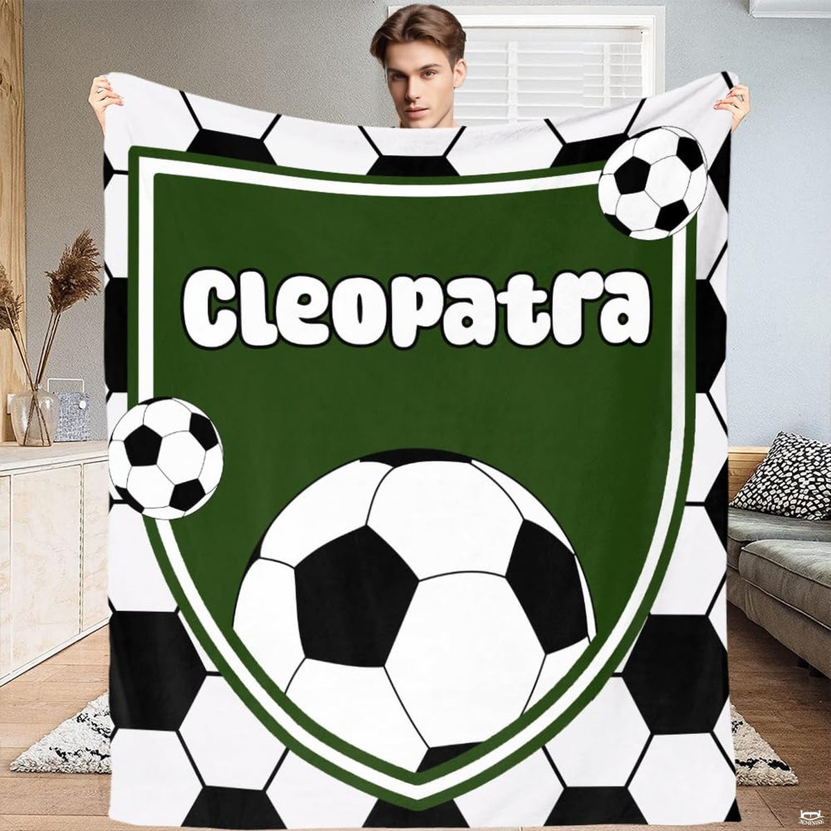 Soccer shield blanket featuring green athletic crest and soccer balls surrounded by hexagonal soccer tiles.