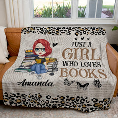 Detail view of illustrated bookworm character and glasses on literary throw blanket.
