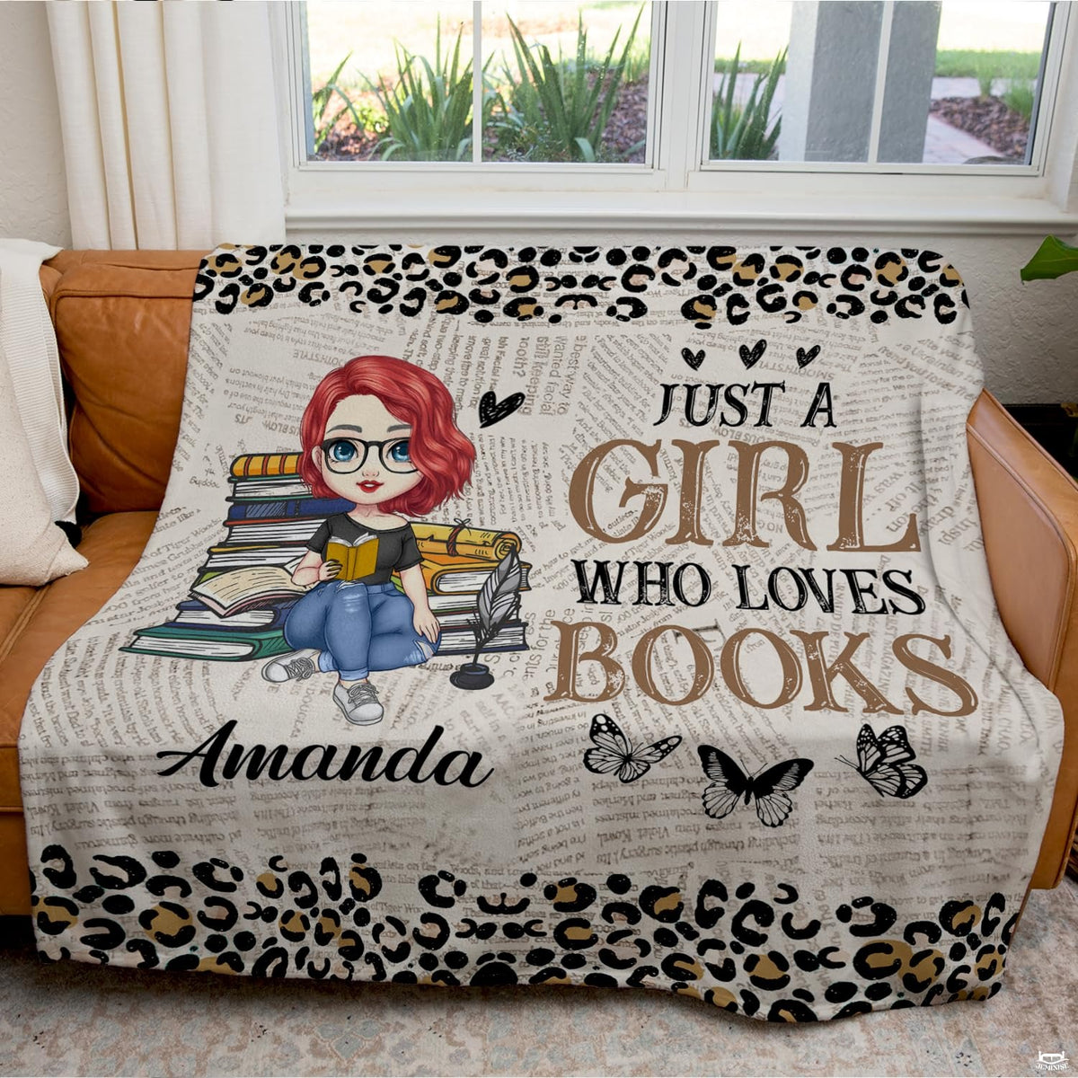 Detail view of illustrated bookworm character and glasses on literary throw blanket.