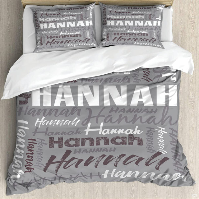 Bedding set featuring diagonal cursive script and distressed typography on neutral grey background.