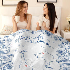 Blue botanical state map throw blanket held open displaying classic blue and white chintz artwork