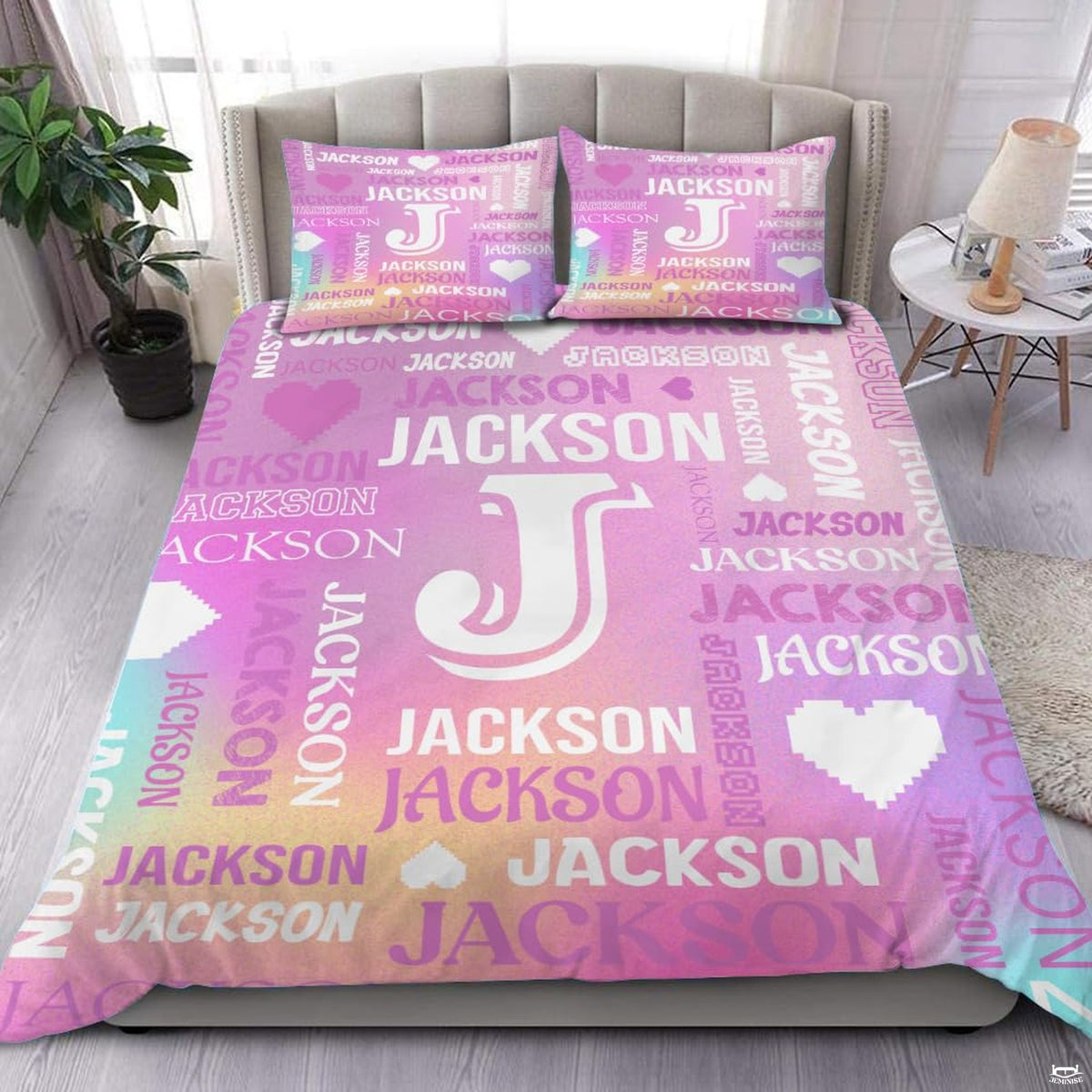Close-up view of bedding detailing bold monogram outline, pixel heart motifs, and multidirectional typography