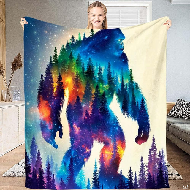 Cosmic Bigfoot galaxy throw blanket displaying Sasquatch silhouette filled with nebula colors and pine trees