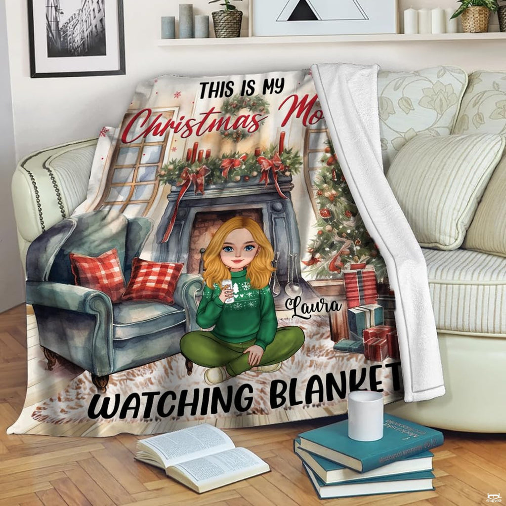 Living room staging of Christmas holiday throw blanket draped across a floral armchair beside books.