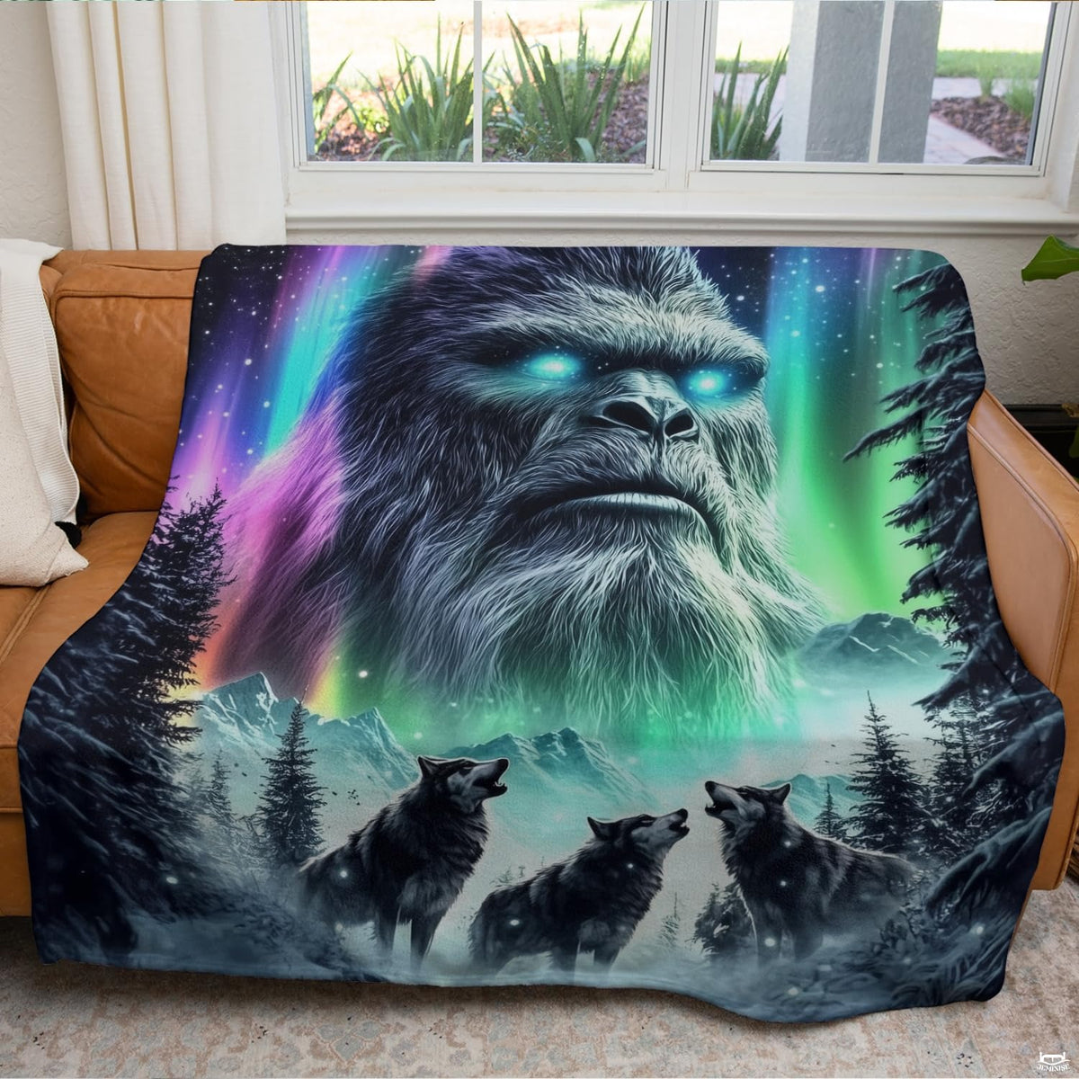 Textile arranged on living room couch displaying cosmic Sasquatch and three wolves in snow.